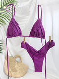 Bikini triangle plissé violet séchant sur une cordelette avec décor bohème