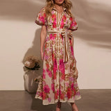 Femme souriante posant avec une robe bohème longue à imprimé floral rose et beige, style chic décontracté