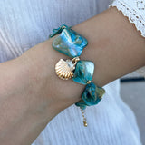 Collier bohème avec perles oranges et pendentif coquillage porté