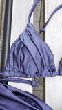 Détail du haut de bikini triangle plissé couleur lavande sur fond bois