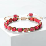 Bracelet bohème perles pierre impériale rouge tressé main sur fond blanc