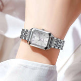 Montre rectangle dorée Emakujitia avec cadran vert portée au poignet