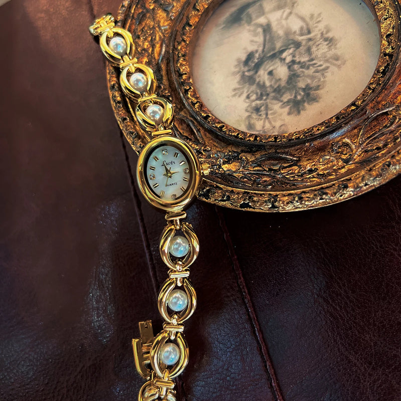 Détail de la montre ovale dorée Emakujitia avec cadran nacré et bracelet perles