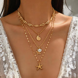 Collier multi-rangs bohème doré sur une femme vêtue d'une robe scintillante