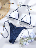Maillot de bain bikini triangle blanc avec liens fins et perles, sur fond clair