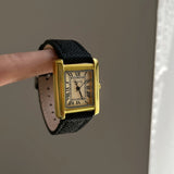 Montre élégante femme cadran doré bracelet cuir noir style rétro chic vue de côté