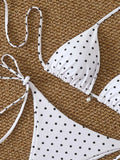Bikini à pois blancs sur fond noir, vue d'ensemble avec accessoires
