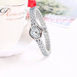 Montre bracelet femme argentée avec cadran blanc sur fond blanc et motifs floraux