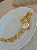 Montre bracelet papillons dorés ouverte, prête à être portée