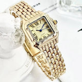 Vue de côté montre carrée femme dorée, couronne bleue, design chic