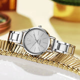 Montre femme argentée sur fond doré, détail du cadran simple