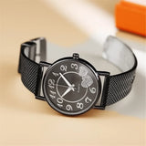 Montre femme dorée rose avec bracelet maille milanaise et cadran cœurs scintillants sur fond clair