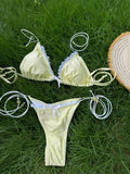 Vue arrière d'un bikini triangle noir sur une plage de sable fin