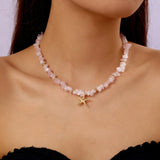 Collier perles coquillages naturelles avec pendentif coquille dorée, porté par une femme