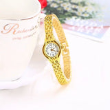 Montre bracelet femme dorée avec cadran blanc sur fond blanc et motifs floraux
