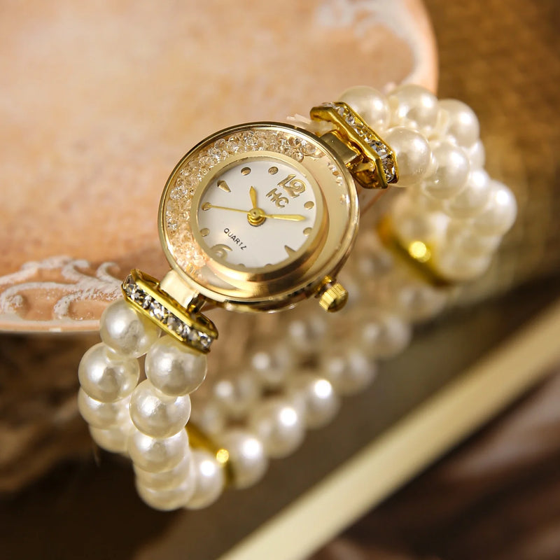 Montre bracelet pour femme avec perles blanches et cadran doré, vue de face