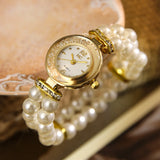 Montre bracelet pour femme avec perles blanches et cadran doré, vue de face