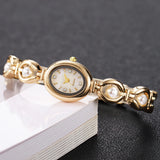 Vue latérale de la montre bracelet dorée et perles
