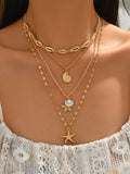 Collier multi-rangs doré avec pendentifs étoile de mer et coquillages sur décolleté