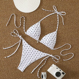 Vue détaillée du bikini blanc à pois noirs, avec perles et liens
