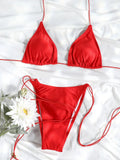 Ensemble bikini triangle rouge vif, bas micro string avec liens ajustables, sur tissu blanc