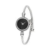 Détail du bracelet tressé et du cadran minimaliste de la montre dorée