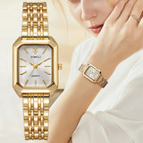 Montre rectangle dorée pour femme avec cadran blanc, portée au poignet