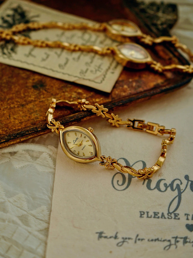 Montre femme dorée rétro avec petit cadran ovale et bracelet ouvragé