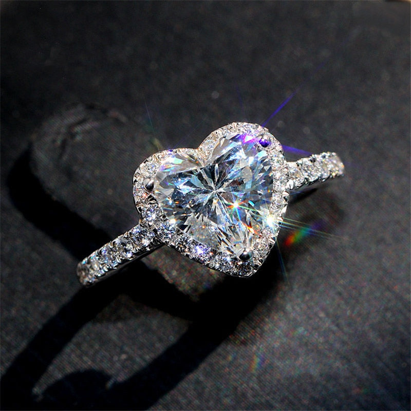 Anillo plateado engastado con piedra en forma de corazón.