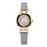 Gros plan du cadran d'une montre femme bohème chic avec chiffres arabes et anneau de strass