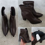 Bottines Chelsea noires, vue de face sur fond de journal