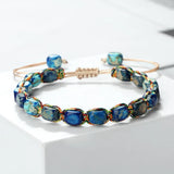 Bracelet bohème perles pierre impériale bleu foncé tressé main sur fond blanc