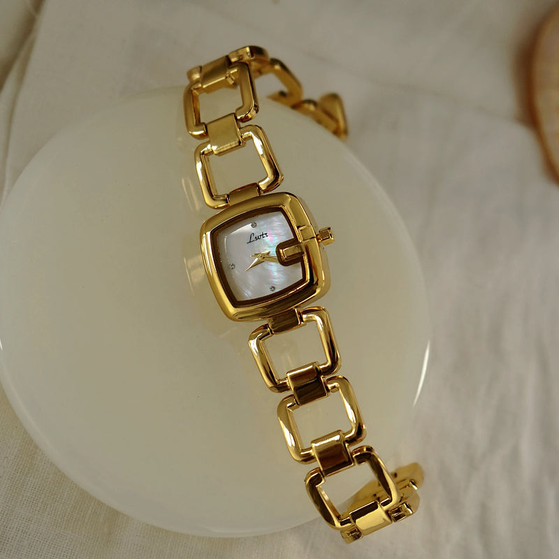 Montre femme luxe bohème dorée avec cadran nacre sur fond blanc