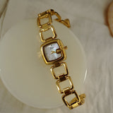 Montre femme luxe bohème dorée avec cadran nacre sur fond blanc