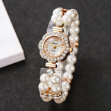 Gros plan sur le cadran et le bracelet de la montre femme ornée de perles et de brillants.