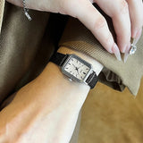 Montre femme vintage carrée GEDI, bracelet cuir marron, boîtier doré, portée au poignet