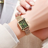 Montre femme carrée dorée avec cadran vert portée au poignet