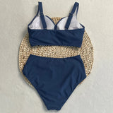 Vue détaillée du haut de maillot de bain croisé bleu marine sur fond clair