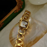 Montre femme dorée élégante, cadran nacre, bracelet acier inoxydable, vue rapprochée