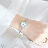 Quatre montres bracelets de différentes couleurs sur un fond blanc