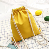 Vue arrière du sac à dos bohème en toile à cordon jaune, montrant les bretelles