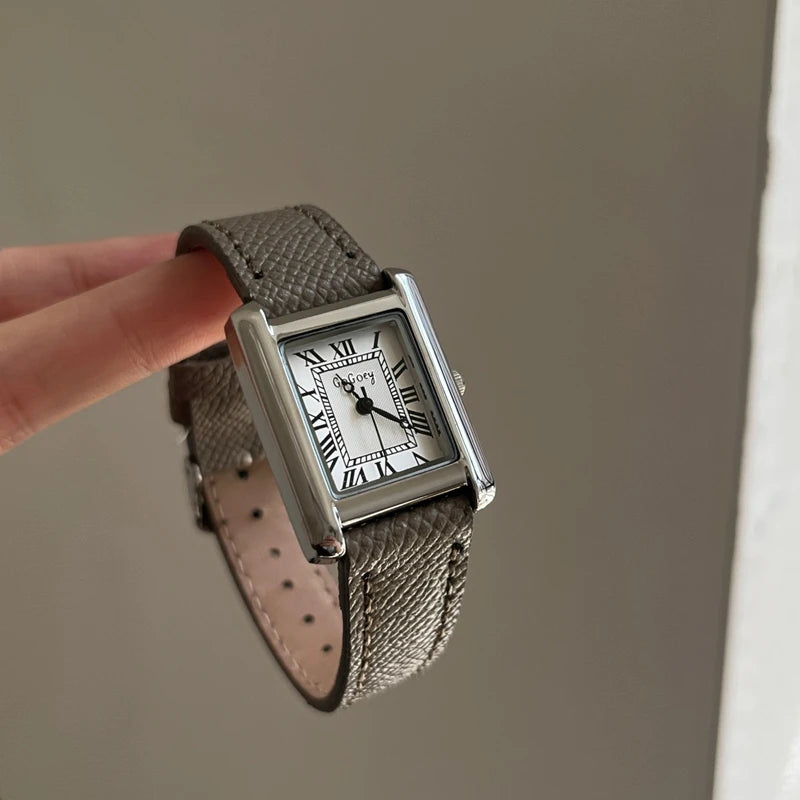Détail montre femme vintage cadran blanc chiffres romains bracelet cuir gris texturé
