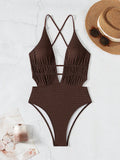 Maillot de bain une pièce texturé brun avec décolleté plongeant et découpes sur fond clair