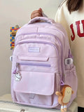 Sac à dos en nylon rose avec dragonne et accessoires mignons, idéal pour étudiants et utilisation quotidienne.