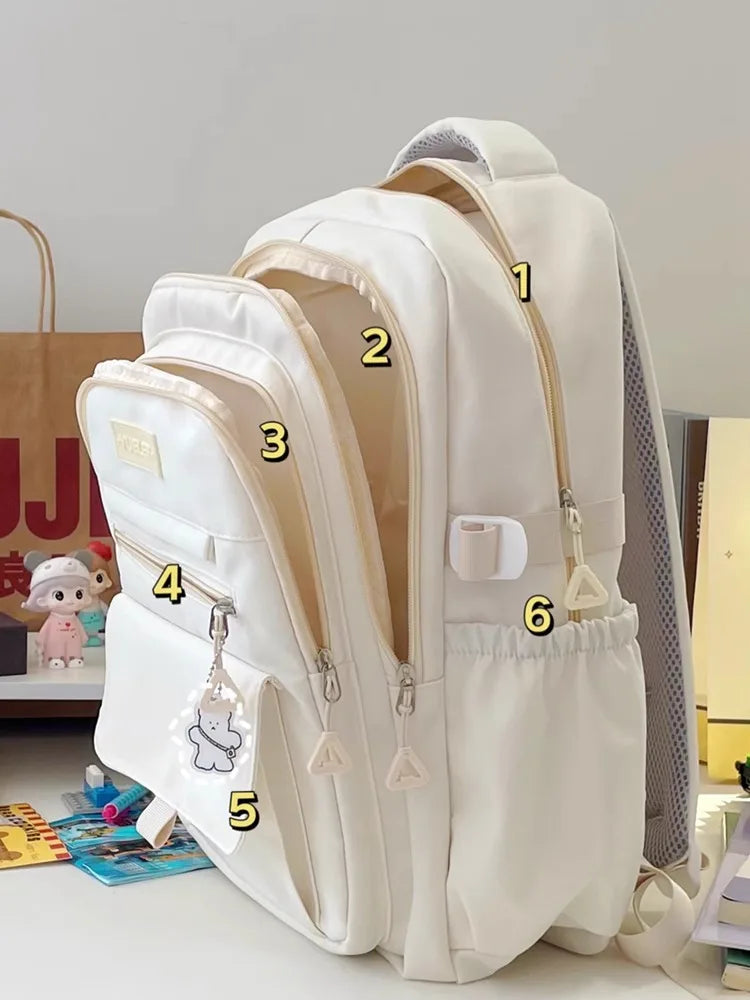 Sac à dos blanc en nylon avec grande capacité et plusieurs poches, idéal pour ordinateur et fournitures scolaires.