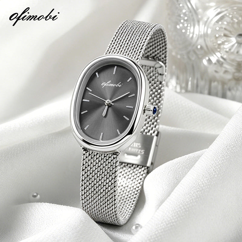 Montre femme cadran ovale gris avec bracelet milanais argenté sur tissu blanc