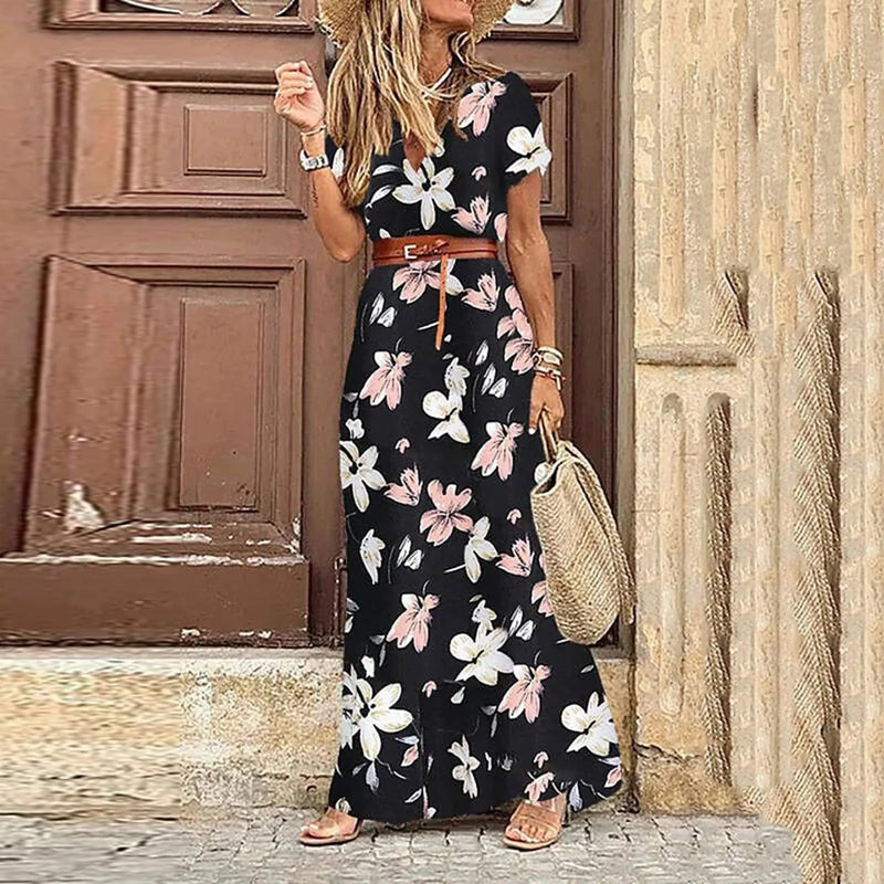 Femme portant une robe longue fleurie noire avec ceinture marron et chapeau de paille