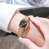 Montre quartz femme dorée au cadran carré noir portée sur un poignet féminin