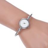 Montre bracelet argentée avec cadran blanc portée au poignet