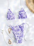 Bikini triangle vert émeraude, bas micro string, sur fond blanc avec accessoires floraux